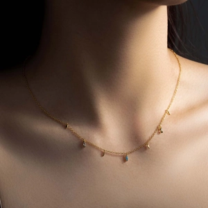 Long gold necklace with marquise-cut light blue and zircon crystals on model