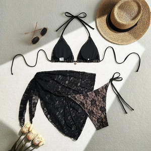 Detailed flat lay of a black lace bikini set with matching mesh beach skirt and sun hat