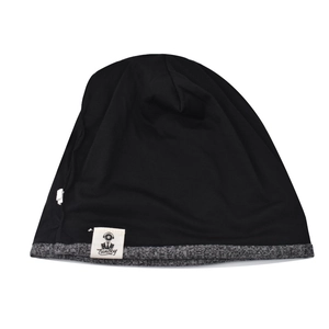 Close-up of knit beanie showing black fabric texture and gray logo tag detail
