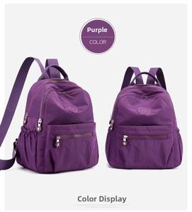 Detail view of purple nylon backpack showing functional multiple zipper pockets