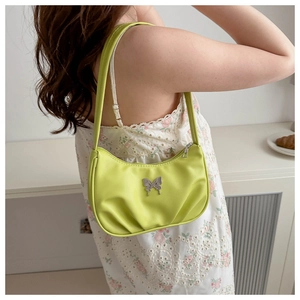 Detailed back view of a fluorescent green pleated shoulder bag with silver butterfly charm