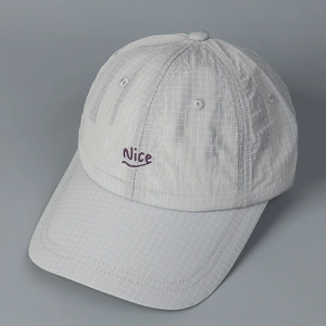 Detail of light gray plaid baseball cap featuring purple Nice embroidery and textured fabric