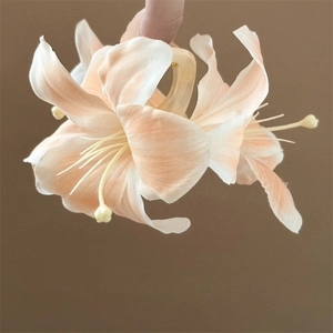 Close-up of pink gradient fabric lily flower hair claw clip with delicate petal details