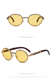 Detail of round sunglasses with yellow lenses, rhinestone frames and wood texture temples