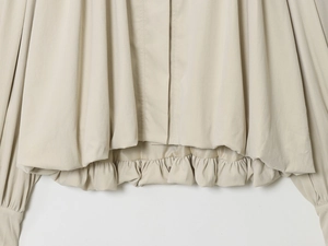 Detailansicht von Plisseesaum und elastischen Bündchen an einer beigen Damenjacke