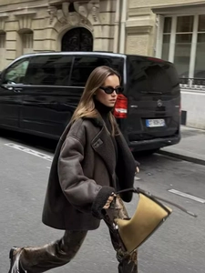 Women's deep brown faux shearling jacket with turn-down collar in a stylish street view