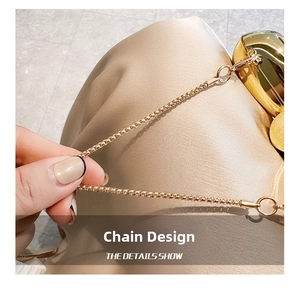 Detailed close-up of golden square link chain with glossy metallic finish for bags
