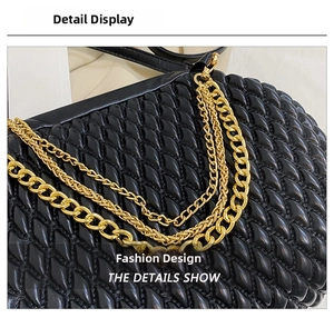 Detailed close-up of woven black leather texture and ornate gold metal chain hardware