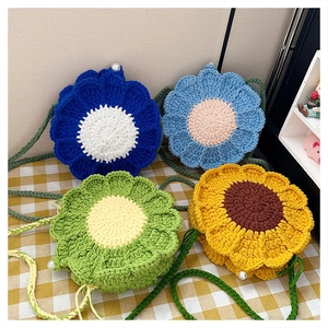 Detail of four colorful floral crochet shoulder bags with pearl button accents