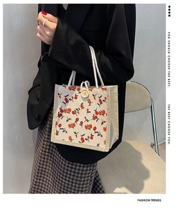 Close-up of small floral linen tote bag featuring woven rope handles and wooden button detail