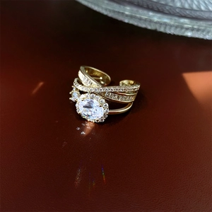 Macro shot of layered gold ring with oval zircon and pavé diamonds on leather