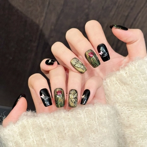 Handgefertigte Kunstnägel mit schwarz-goldener Glitzerbasis, roten Rosen und Schmetterlingen