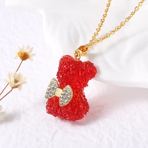 Dettaglio del ciondolo a forma di orsetto rosso in cristallo con fiocco di strass dorato