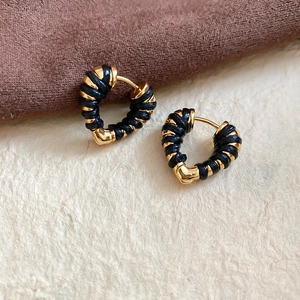 Détail de boucles d'oreilles cœur tissé or et noir montrant la texture et taille 2cm