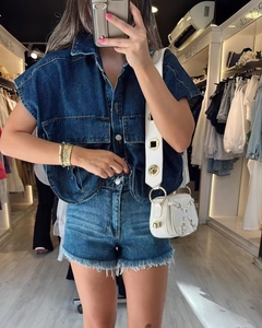 Détail du tissu denim bleu foncé avec des boutons métalliques de qualité sur la veste