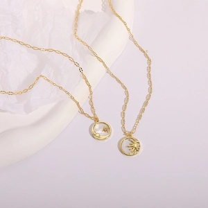 Detailed view of sun and moon pendants on elegant 14K gold plated brass necklaces
