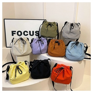 Multiple colorful drawstring bucket bags displayed in various nylon fabric options