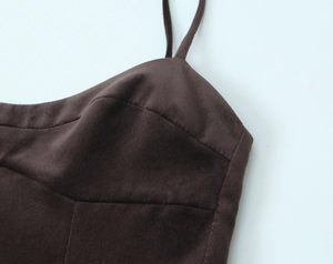 Détail de la robe en velours marron foncé montrant les coutures et fines bretelles
