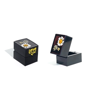Detail view of square resin ring box with dried daisy inlay and yellow Love text