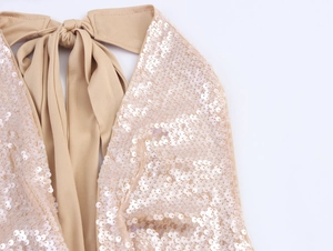 Detailed view of champagne gold sequins and halter neck ties on a stylish party set