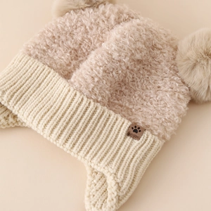 Cappello invernale in maglia per bambini con paraorecchie e due pompon beige