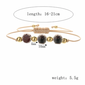 Detail view of woven bracelet with ceramic flower beads and metal accents on white background
