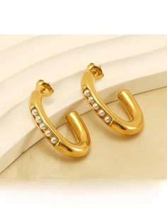 Detail showing gold-plated titanium steel U-shape earrings with small pearls in close-up