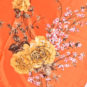 Dettaglio di un foulard di seta lucida arancione con stampe di peonie e bacche