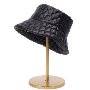 Sombrero de pescador acolchado negro para otoño e invierno en un soporte de metal dorado