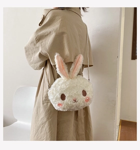 Detail of cute white plush rabbit bag featuring elegant pearl strap and soft fur texture