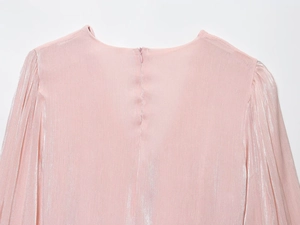 Détail de la robe rose métallisée montrant la fermeture éclair invisible et la texture