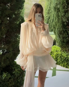 Detailed view of beige pleated chiffon mini dress with puff sleeves and waist tie