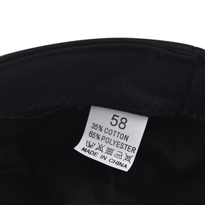 Detail shot of the black newsboy hat's wash label showing 35% cotton and 65% polyester composition
