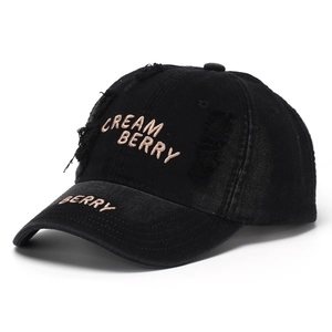 Detail of black distressed baseball cap with pink gold Cream Berry embroidery and ripped style