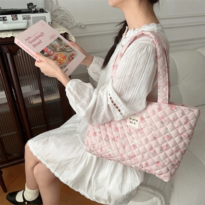 Quilted tote bag with cute bear pattern worn by a model in a warm indoor home setting