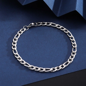 Detail of silver stainless steel Cuban link bracelet with lobster clasp on geometric background
