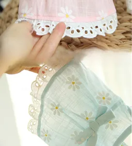 Detail of pet summer dress featuring white daisy prints and exquisite lace trim borders