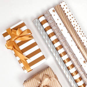 Rose gold and white gift wrapping paper rolls with striped and polka dot patterns