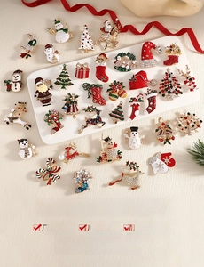 Detail of Christmas brooches with Santa and reindeer motifs in enamel and crystals