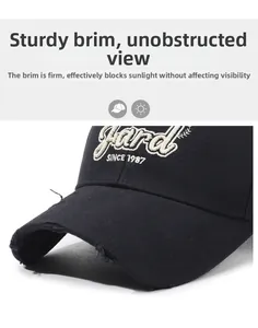 Detail of frayed edge brim and beige Yard SINCE 1987 embroidery on black baseball cap
