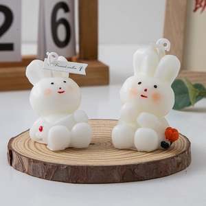 White bunny scented candle with floral accents on a wooden base for home decor