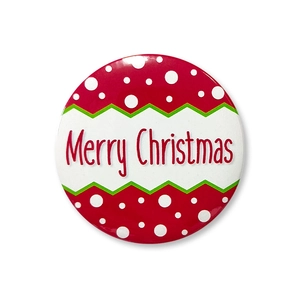 Macro detail of 58mm Merry Christmas tinplate badge with red polka dots and green border