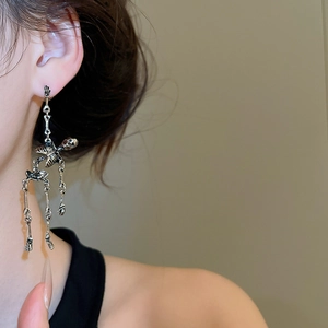 Macro shot of a silver gothic skull earring with articulated joints on model's ear