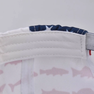 Détail de l'intérieur de la casquette montrant le tissu blanc à motifs poissons et étoiles