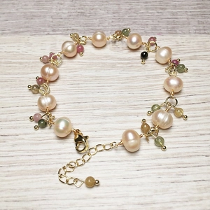 Close-up of handmade freshwater pearl bracelet with colorful tourmaline and gold lobster clasp
