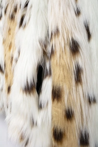 Macro shot of faux leopard fur texture with ivory and brown plush fibers for women's coat