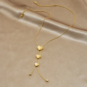Elegant gold heart pendant necklace with matte texture on champagne silk background