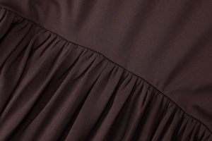 Close-up detail of the chocolate brown pleated fabric texture and stitching craftsmanship