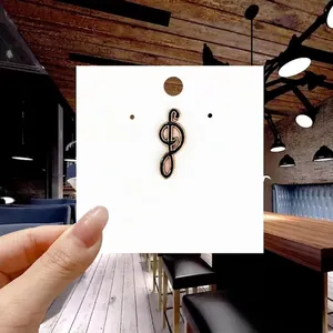 Close-up of G-clef musical note enamel pin badge with gold trim on a white display card