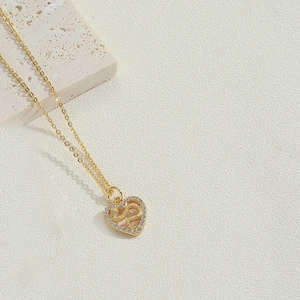 Detail of 14K gold plated heart pendant featuring zircon micro-pave and S-shaped inlay